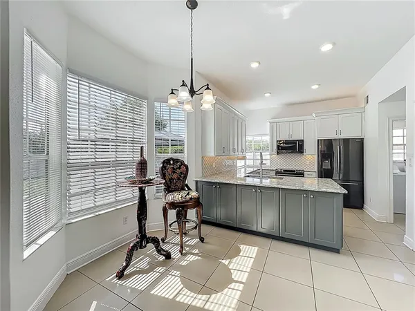 a work place with kitchen island granite countertop furniture and a chandelier