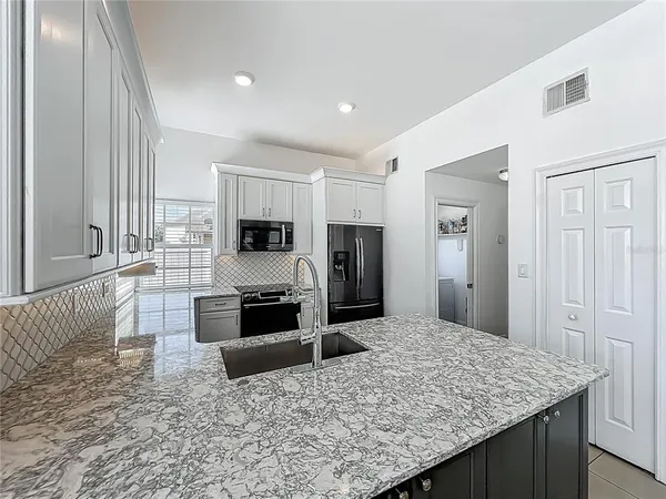 a kitchen with stainless steel appliances granite countertop a stove refrigerator and cabinets