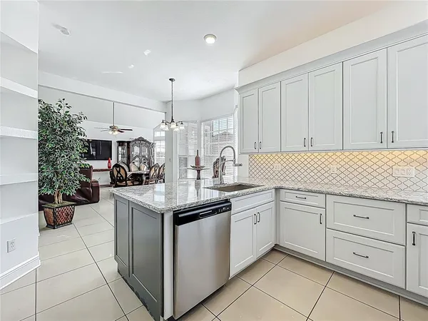a kitchen with granite countertop white cabinets and white appliances