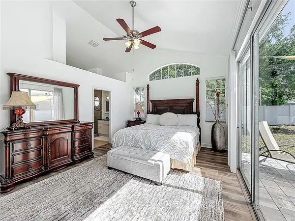 a bedroom with a large bed and a chandelier