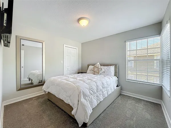 a bedroom with a bed and a lamp next to a window