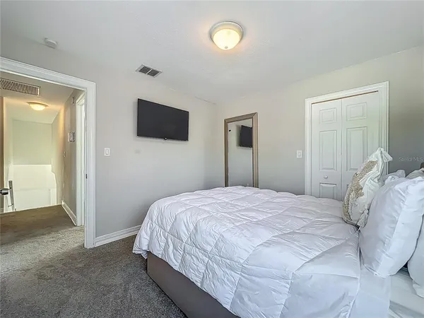 a bedroom with a bed and a flat screen tv