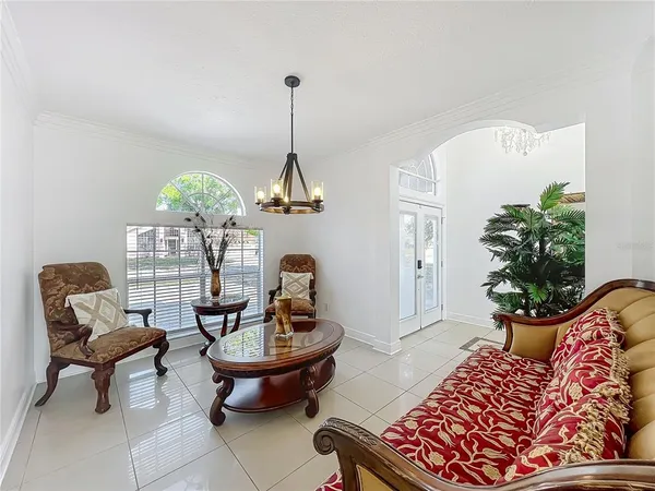 a living room with furniture flowerpot and a chandelier