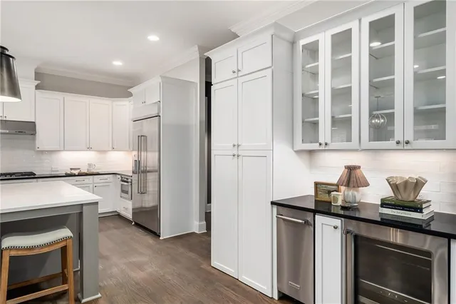 a living room with stainless steel appliances furniture fireplace and kitchen view