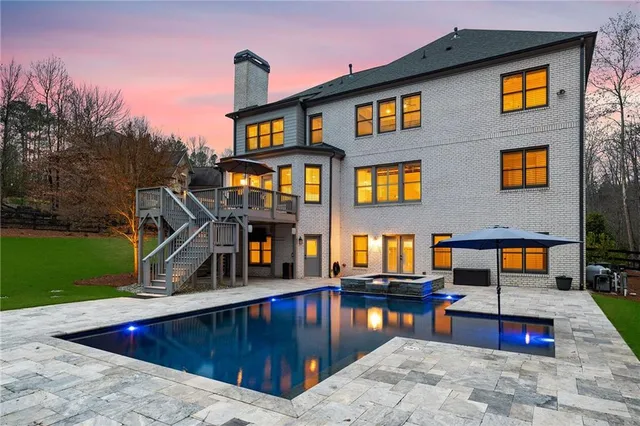 a bathroom with a granite countertop sink toilet mirror and bathtub