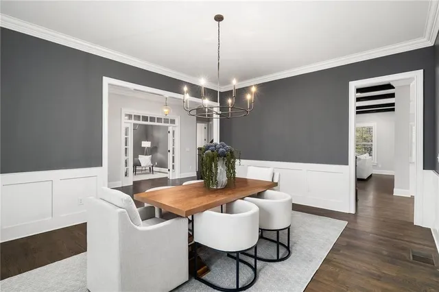 a living room with furniture kitchen view and a wooden floor