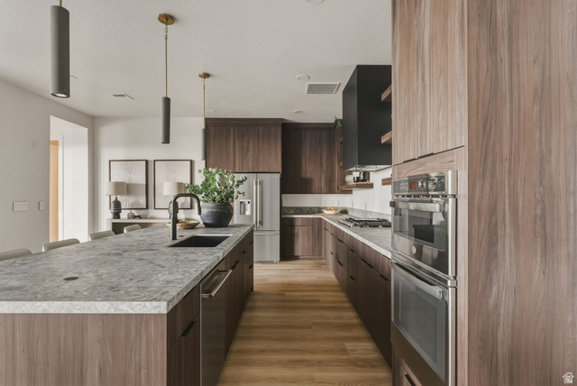 923 North Emery Lane Elk Ridge, UT 84651 - Photo 56 of 101 Contemporary kitchen featuring wood-finish cabinetry, light-toned stone countertops, and stainless steel appliances
