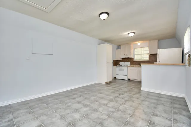 a kitchen with white cabinets and white appliances