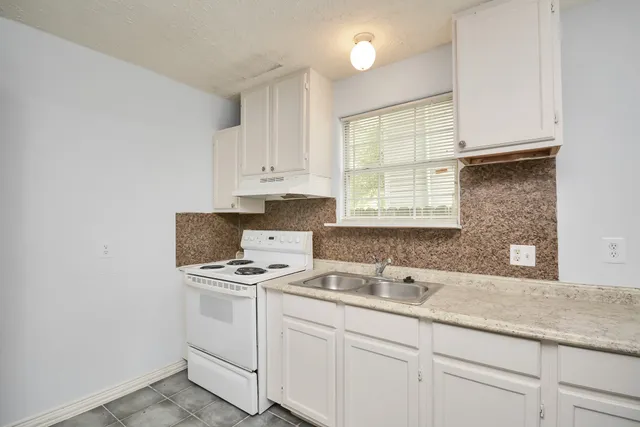 a kitchen with a sink cabinets and window