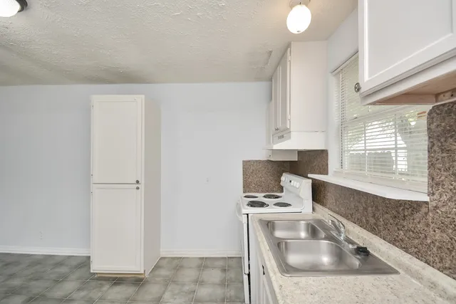 a kitchen with white cabinets and stainless steel appliances
