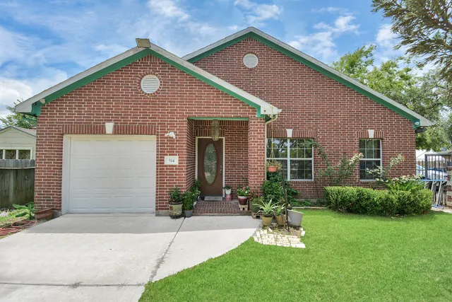 a front view of a house with a garden and plants