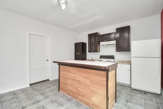 a kitchen with a stove top oven and refrigerator