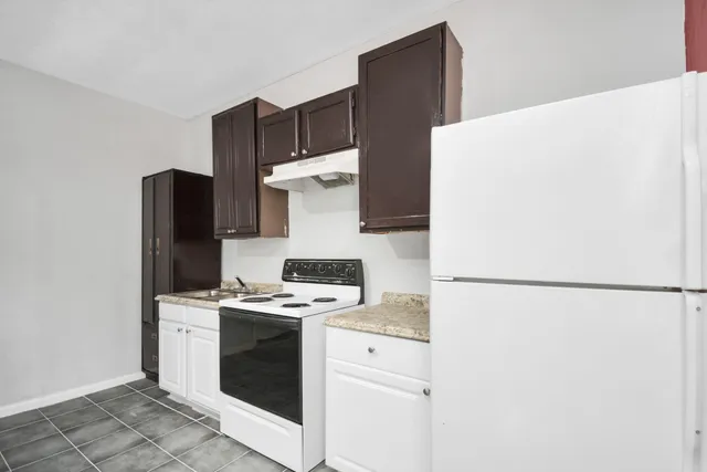 a kitchen with a refrigerator sink and cabinets