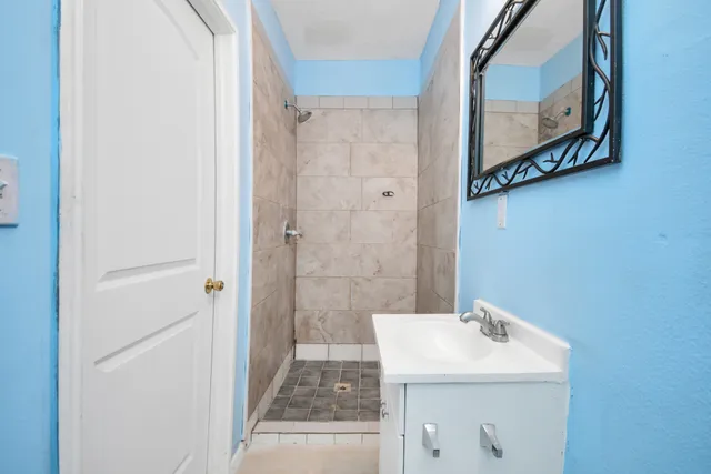 a bathroom with a sink a mirror and shower