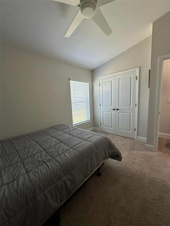 6245 Southwest 96th Place Ocala, FL 34476 - Photo 17 of 38 a bed sitting in a spacious bedroom next to a window and a chandelier