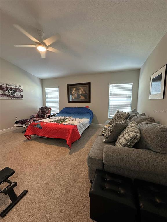 6245 Southwest 96th Place Ocala, FL 34476 - Photo 23 of 38 a spacious bedroom with a bed couch and window