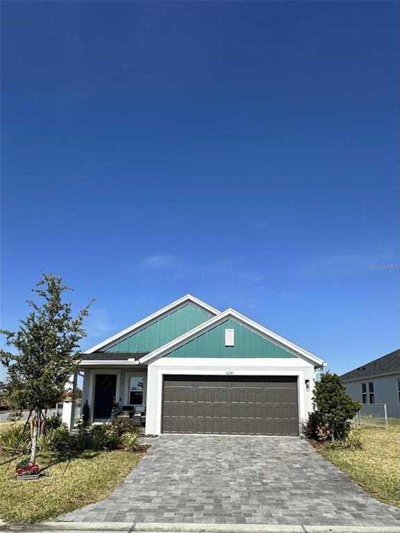 6245 Southwest 96th Place Ocala, FL 34476 - Photo 3 of 38 a front view of a house with a yard and garage