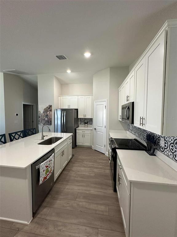6245 Southwest 96th Place Ocala, FL 34476 - Photo 8 of 38 a large kitchen with a large counter top stainless steel appliances and white cabinets