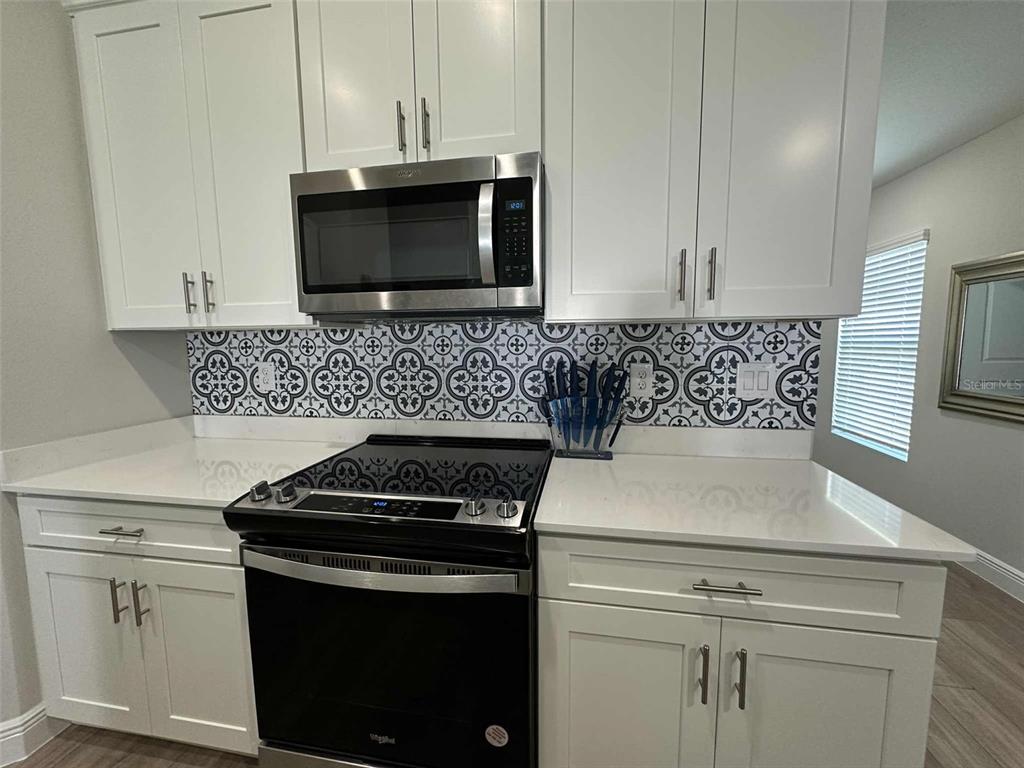 6245 Southwest 96th Place Ocala, FL 34476 - Photo 10 of 38 a kitchen with microwave cabinets and stove top oven