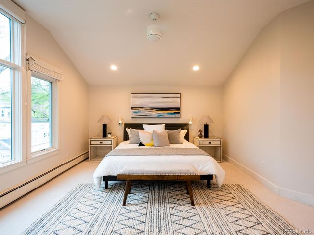 a large bedroom with a bed and wooden floor