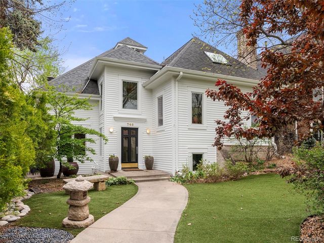 a front view of a house with a garden and plants