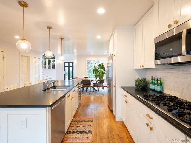 a kitchen with sink stove and cabinets