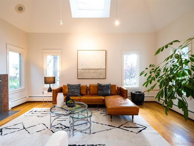 a living room with furniture a wooden floor and a large window