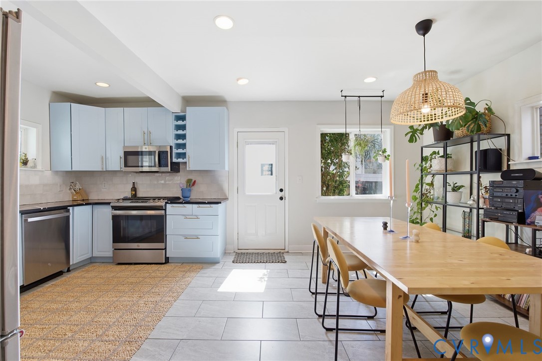 1602 Decatur Street Richmond, VA 23224 - Photo 12 of 25 a kitchen with stainless steel appliances granite countertop a stove a refrigerator a kitchen island a sink a stove a dining table and chairs