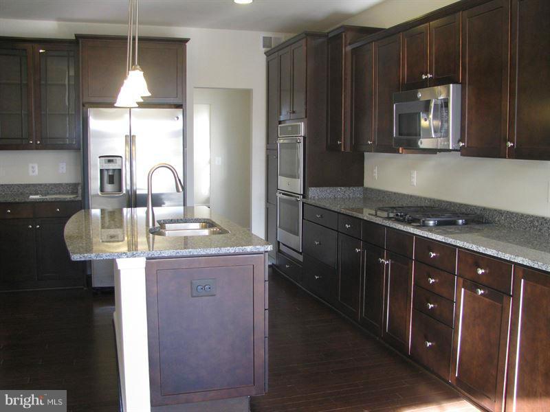 7207 Maisson Ridge Circle Beltsville, MD 20705 - Photo 4 of 5 a kitchen with kitchen island granite countertop a sink stainless steel appliances and cabinets