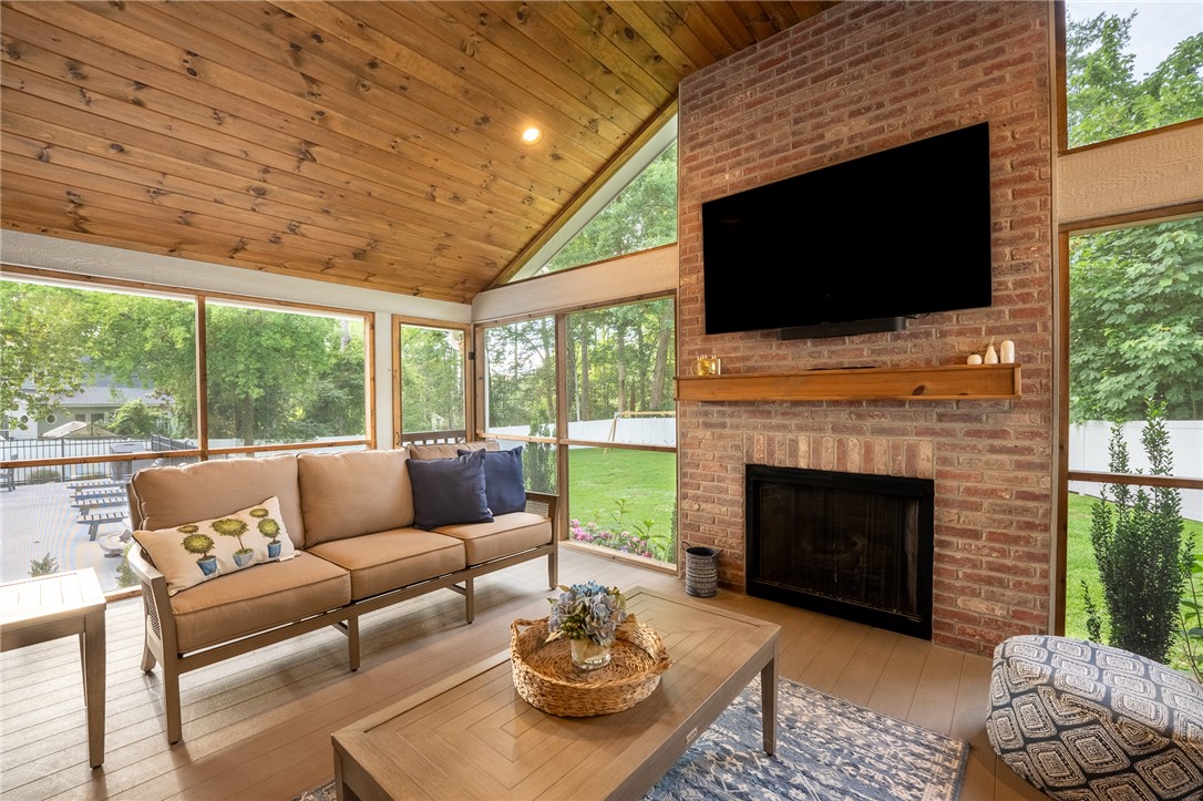 103 Riggs Drive Clemson, SC 29631 - Photo 19 of 50 A spacious screened porch with vaulted ceilings and a brick fireplace overlooks a private yard.