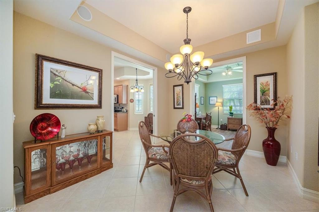 8637 Champions Point, Unit 902 Naples, FL 34113 - Photo 11 of 26 Dining room featuring light tile patterned floors, baseboards, visible vents, and a notable chandelier
