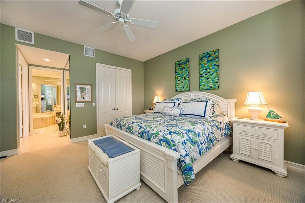 8637 Champions Point, Unit 902 Naples, FL 34113 - Photo 14 of 26 Bedroom featuring a closet, light colored carpet, and visible vents