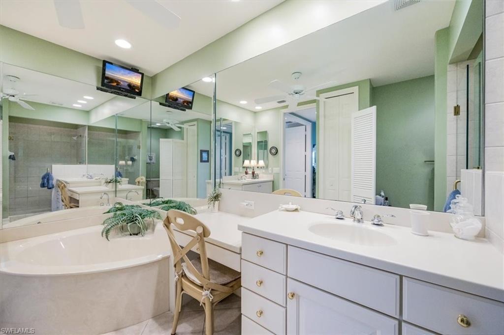 8637 Champions Point, Unit 902 Naples, FL 34113 - Photo 16 of 26 Full bathroom with a bath, a shower stall, ceiling fan, a sink, and tile patterned flooring