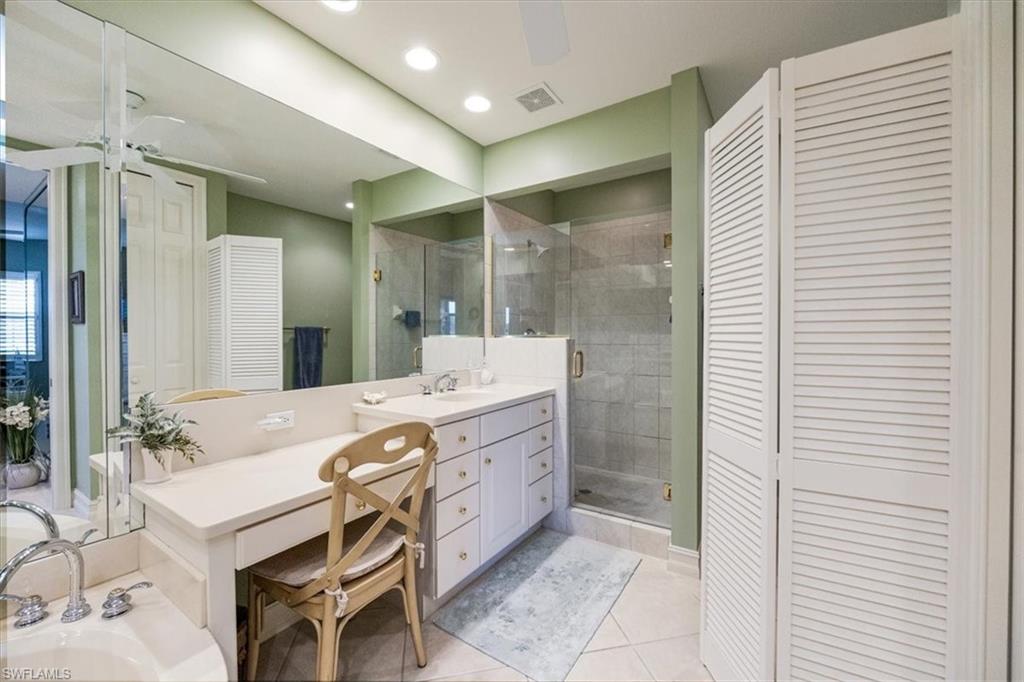 8637 Champions Point, Unit 902 Naples, FL 34113 - Photo 17 of 26 Bathroom featuring tile patterned flooring, vanity, a stall shower, visible vents, and a closet