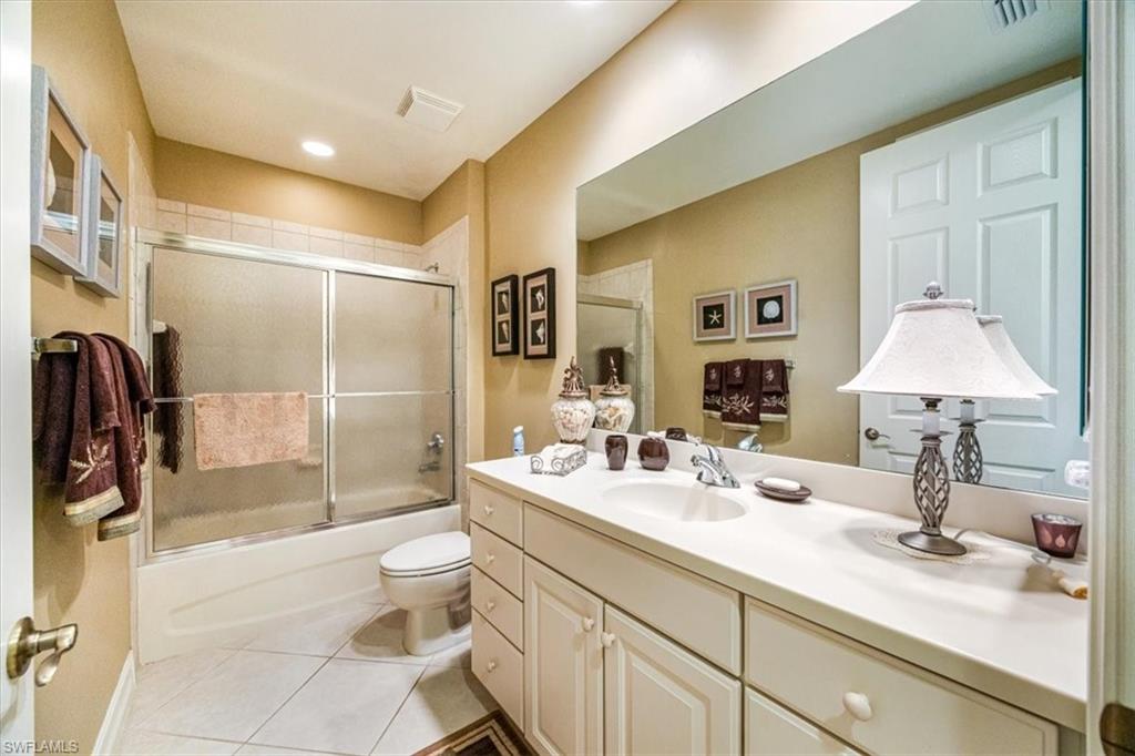 8637 Champions Point, Unit 902 Naples, FL 34113 - Photo 19 of 26 Full bathroom with visible vents, toilet, tile patterned floors, vanity, and enclosed tub / shower combo