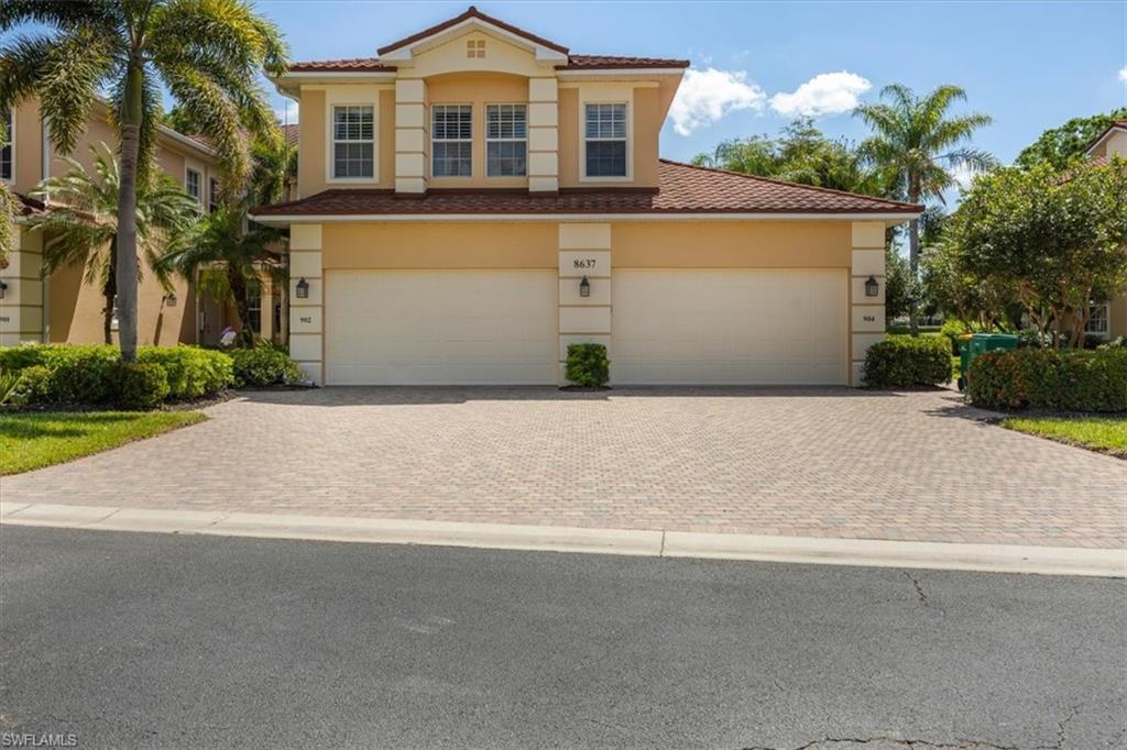 8637 Champions Point, Unit 902 Naples, FL 34113 - Photo 2 of 26 Mediterranean / spanish-style home featuring decorative driveway, a tile roof, and stucco siding