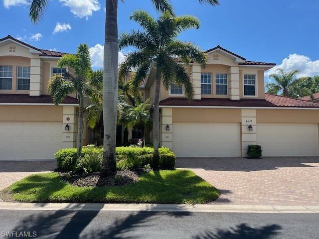 8637 Champions Point, Unit 902 Naples, FL 34113 - Photo 26 of 26 View of front of property featuring stucco siding, a garage, and decorative driveway