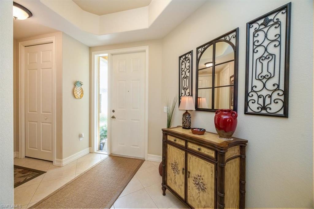 8637 Champions Point, Unit 902 Naples, FL 34113 - Photo 4 of 26 Foyer entrance with light tile patterned flooring, a tray ceiling, and baseboards