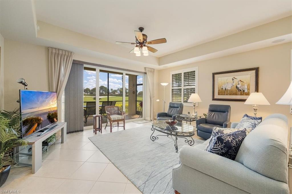 8637 Champions Point, Unit 902 Naples, FL 34113 - Photo 5 of 26 Living room featuring a tray ceiling, ceiling fan, and light tile patterned floors