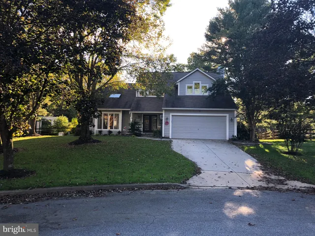 a front view of a house with a yard and a garden