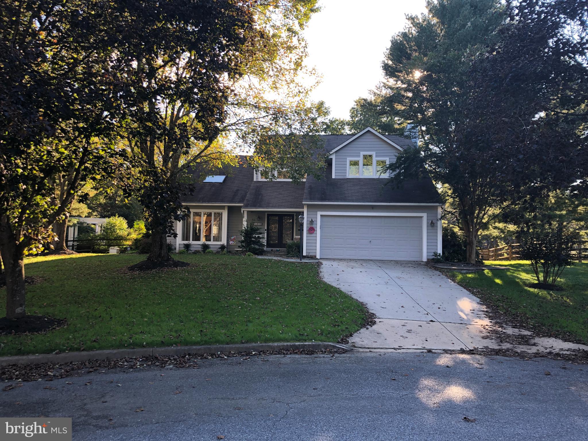 a front view of a house with a yard and a garden
