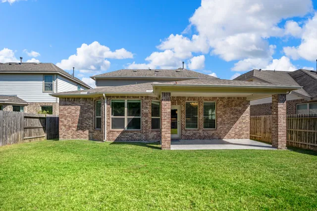 a view of a house with a yard and sitting area