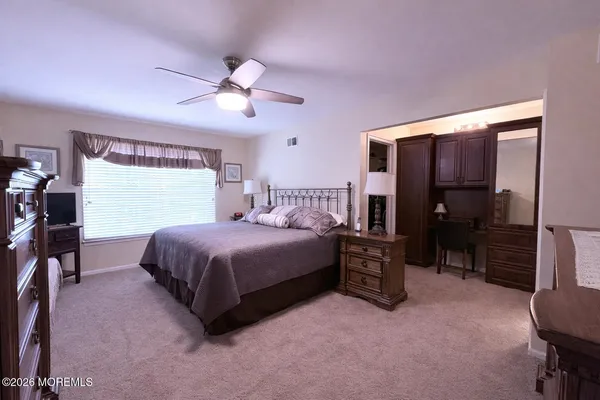 a spacious bedroom with a bed and a chandelier