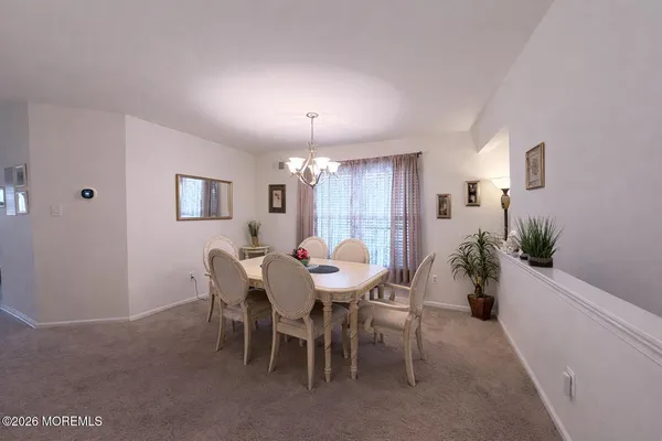 a view of a dining room with furniture and chandelier