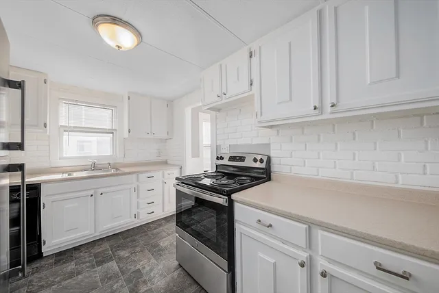 a kitchen with cabinets appliances a sink and a counter top space