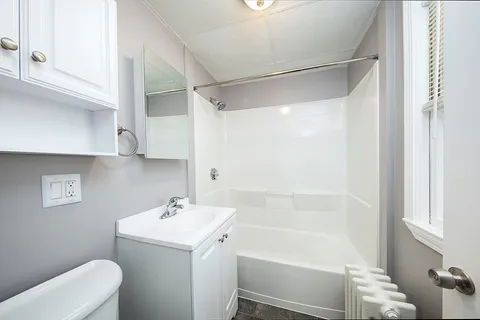 a bathroom with a sink a toilet and shower
