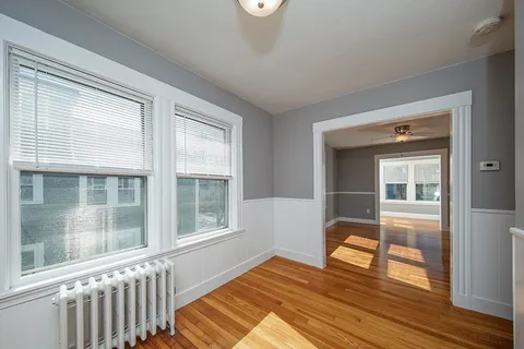 a view of a livingroom with wooden floor and a window