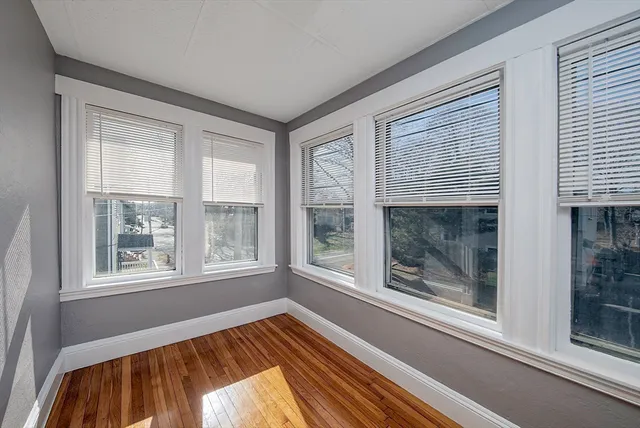 a view of a livingroom with wooden floor and a window