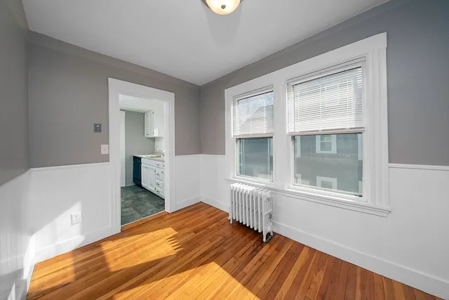 a view of a bedroom with wooden floor and windows