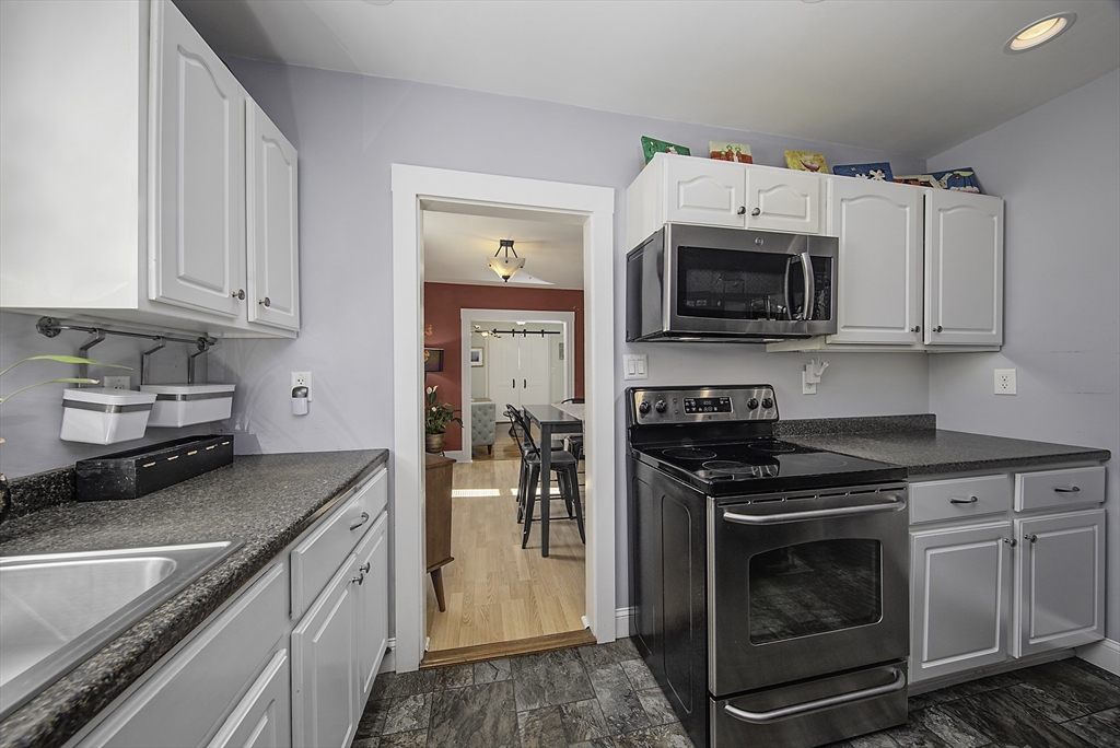 46 Winthrop Avenue Beverly, MA 01915 - Photo 3 of 29 a kitchen with granite countertop a stove top oven microwave and cabinets